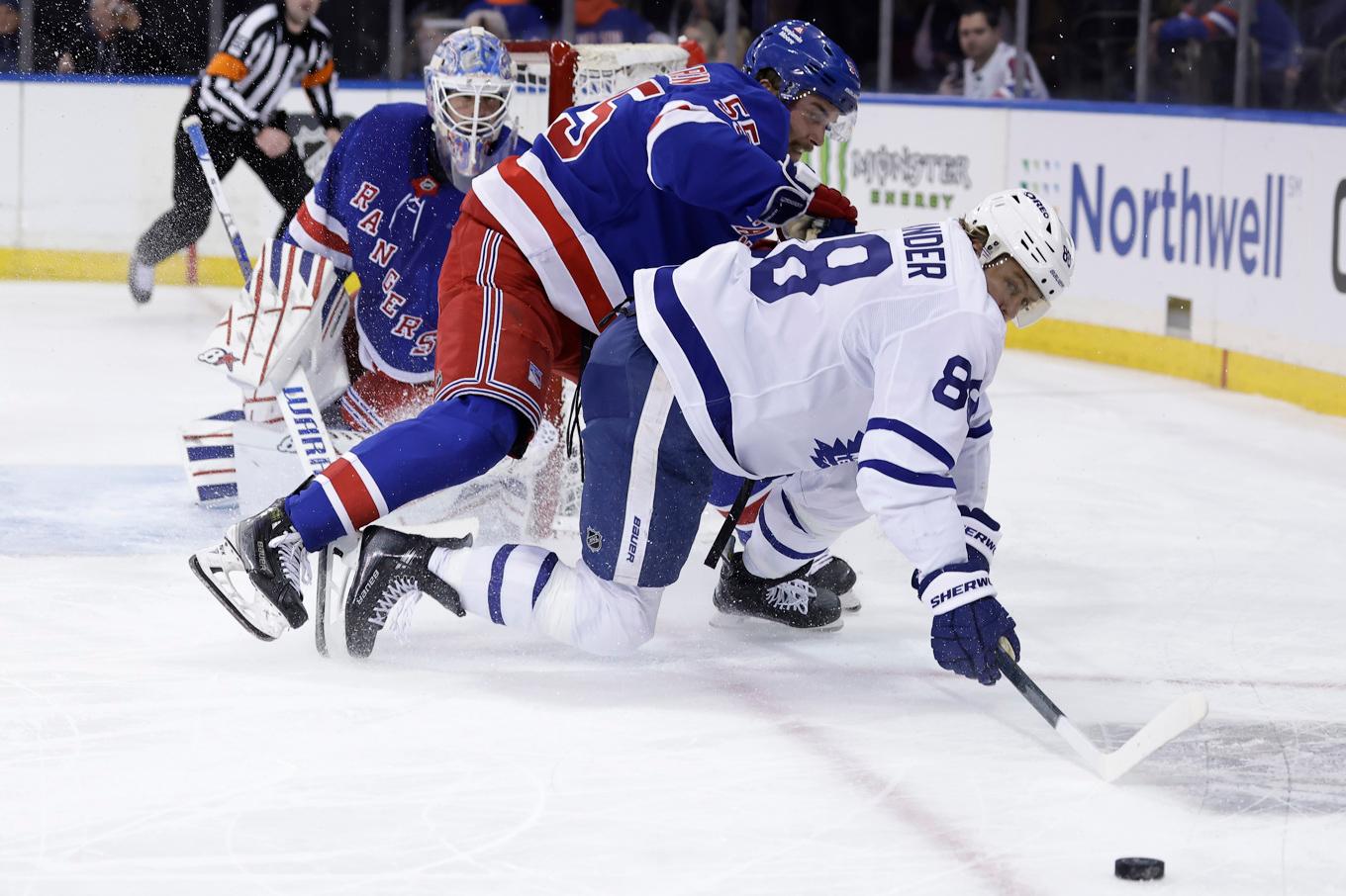 Torontos stjärnforward William Nylander slåss om pucken med Rangersbacken Ryan Lindgren i ryggen. Foto: Adam Hunger/AP/TT