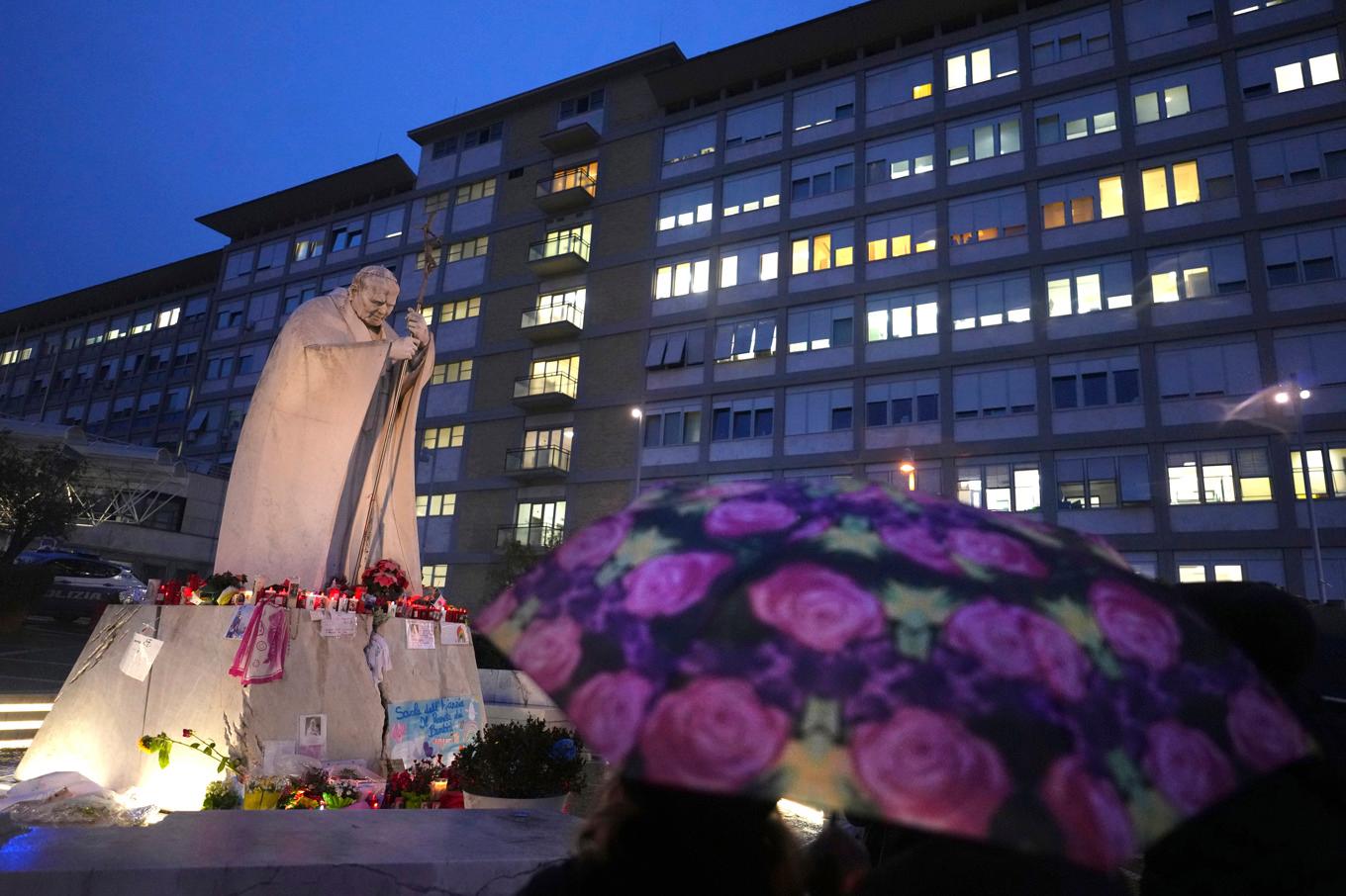 Människor vakar utanför Agostino Gemelli-sjukhuset i Rom där påven vårdas sedan den 14 februari. Foto: Kirsty Wigglesworth/AP/TT