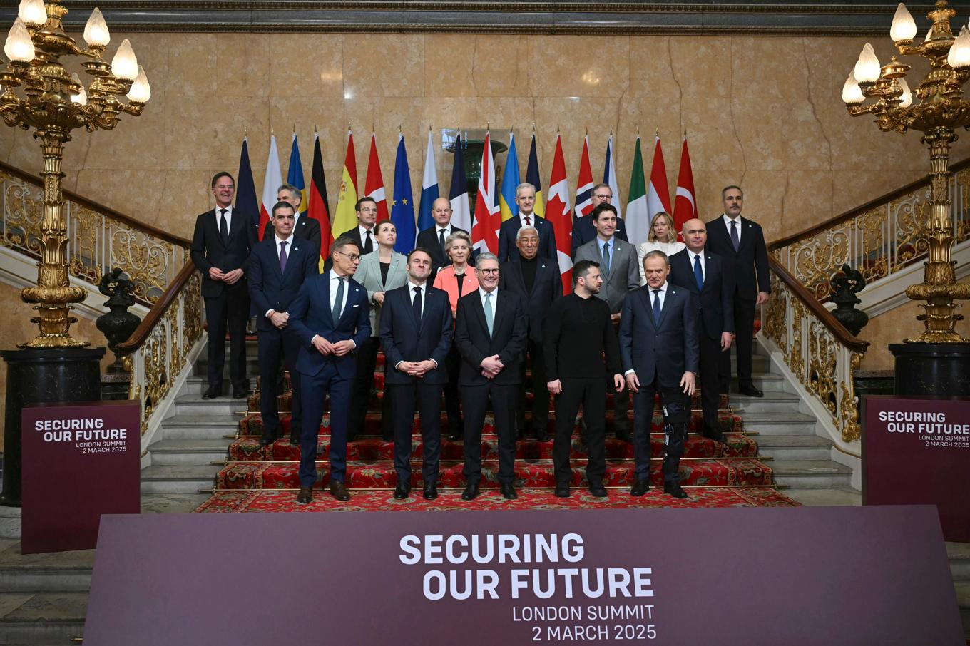 19 ledare från Europa och Kanada inne i Lancaster House i London, med Storbritanniens premiärminister Keir Starmer och Ukrainas president Volodymyr Zelenskyj i mitten längst fram. Foto: Justin Tallis/AP/TT