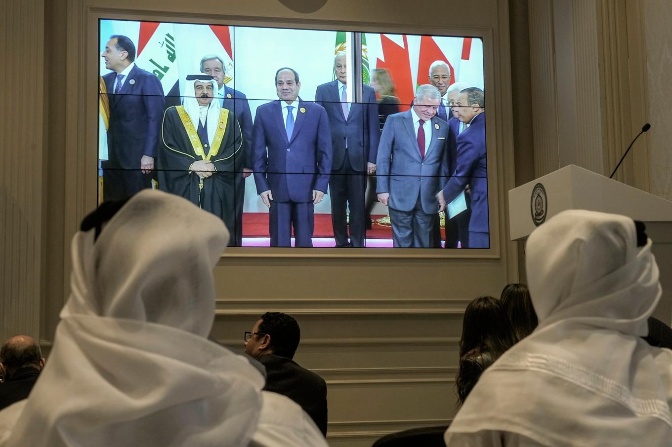 Journalister tittar på en tv-skärm med ledare från arabländerna som samlas för toppmötet i Kairo. Foto: Amr Nabil/AP/TT