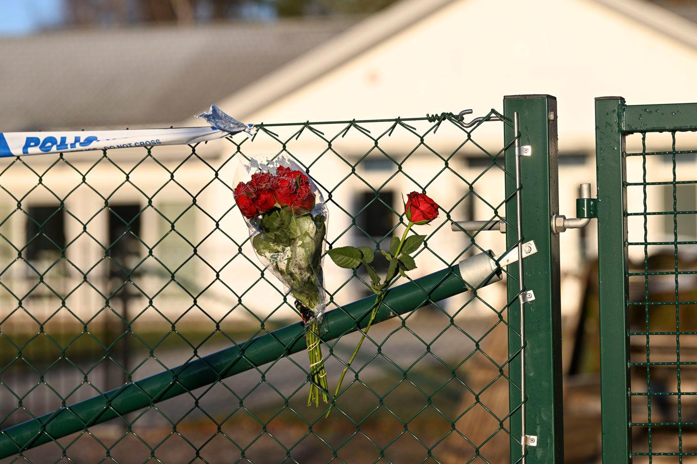 Blommor på stängslet utanför LSS-boendet i Enköping där en ung kvinna i personalen mördades i november 2022. Arkivbild. Foto: Fredrik Sandberg/TT