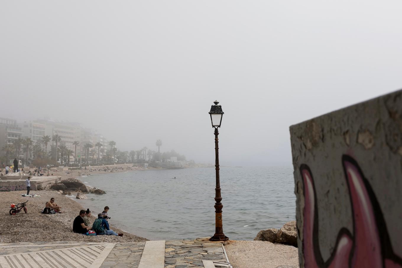 Den varma luften kommer med sandiga vindar från Sahara, vilket också förklarar diset i luften, här i Palaio Faliro nära Aten. Foto: Yorgos Karahalis/AP/TT