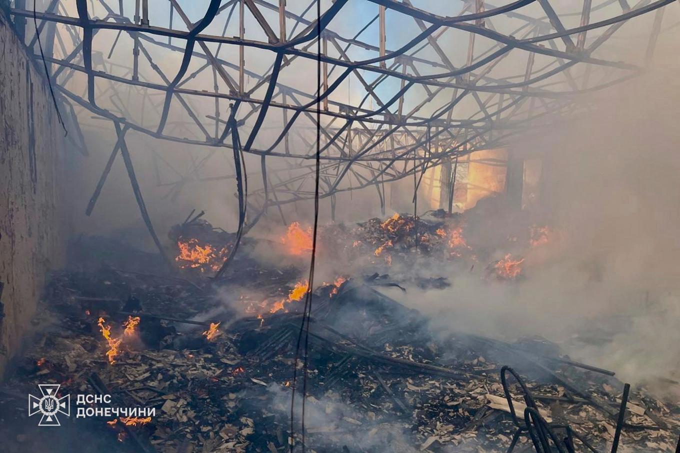 Räddningstjänsten släcker en brand i en lagerlokal till följd av den ryska attacken i staden Kostiantynivka. Foto: Ukrainas räddningstjänst via AP/TT