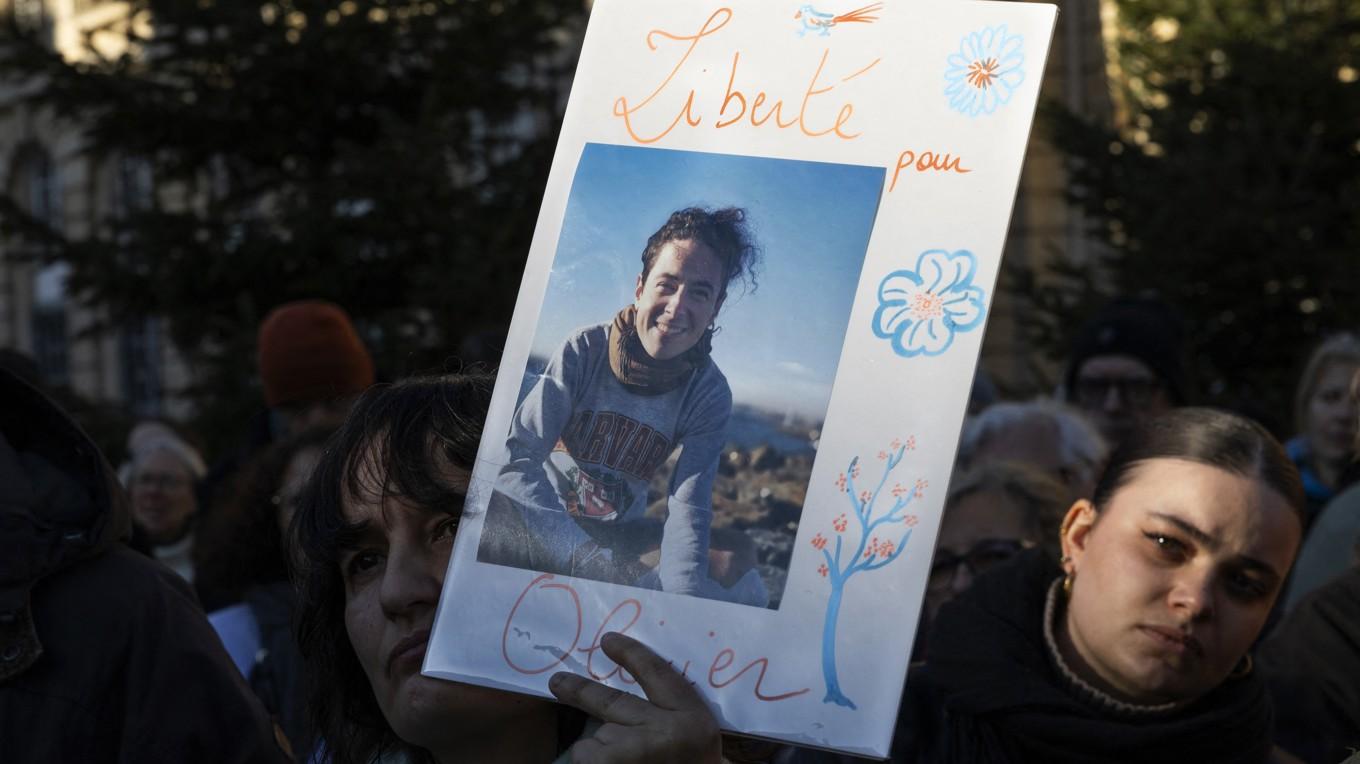 En kvinna håller upp en bild på Olivier Grondeau i samband med en demonstration i Paris den 1 februari i år. Foto: Sebastien Dupuy/AFP via Getty Images