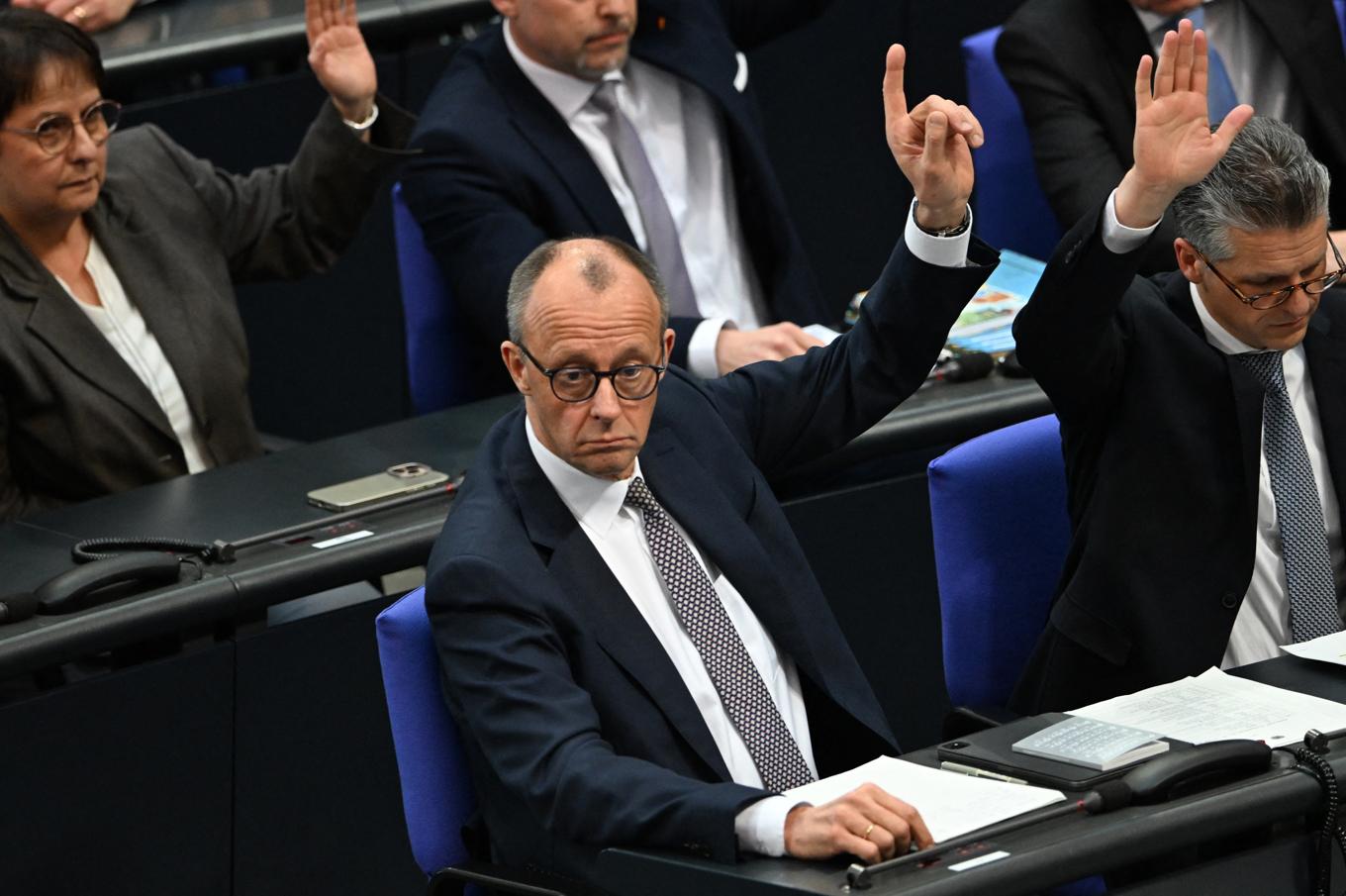 Tysklands blivande förbundskansler Friedrich Merz röstar i förbundsdagen. Hans överenskommelse med SPD som möjliggör stora lån har fått blandade reaktioner. Foto: RALF HIRSCHBERGER/AFP via Getty Images