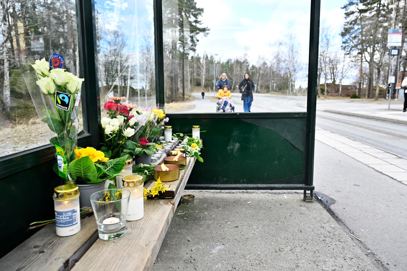 Blommor och ljus i en busskur efter att en man i 18-årsåldern blev skjuten på en buss vid platsen. Foto: Pontus Lundahl/TT