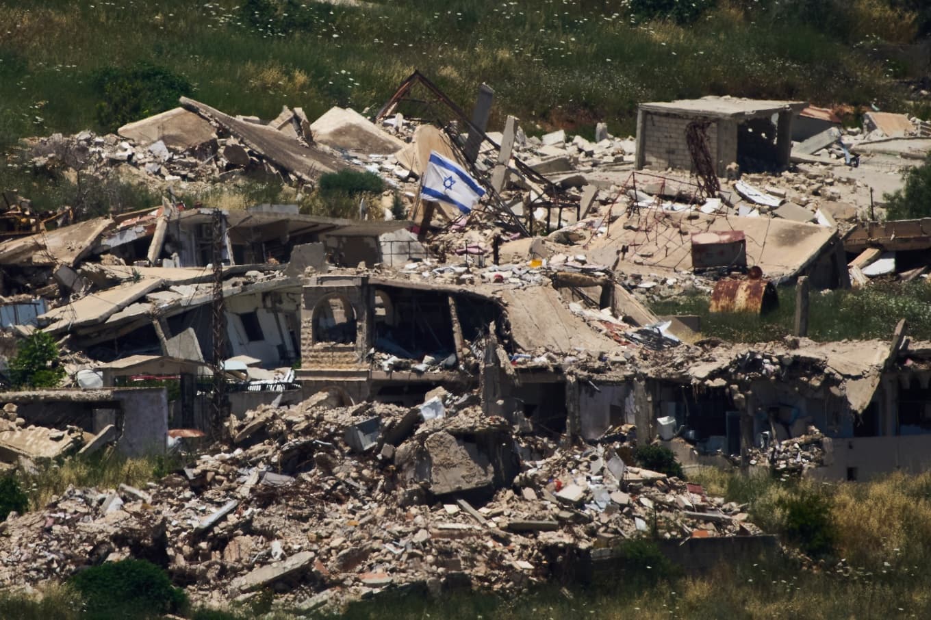 En israeliska flagga på en förstörd byggnad i södra Libanon. Bild från i torsdags. Foto: Ariel Schalit /AP/TT