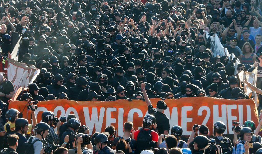 
Svartklädda demonstranter protesterade på Hamburgs gator dagen innan det stora G20-mötet inleds. Demonstranterna samlas under banderollen "Welcome to hell" (Välkommen till helvetet). Foto: Michael Probst /AP/TT                                            