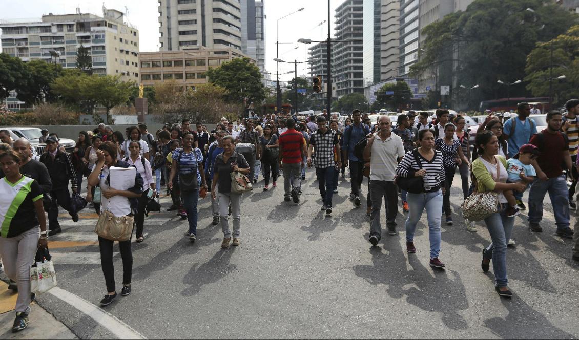 Människor promenerar hemåt sedan strömavbrottet slagit ut tunnelbanan i Caracas. Foto: Fernando Llano/AP/TT