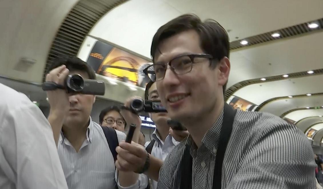 Alek Sigley anländer till flygplatsen i Peking. Foto: Emily Wang/AP/TT