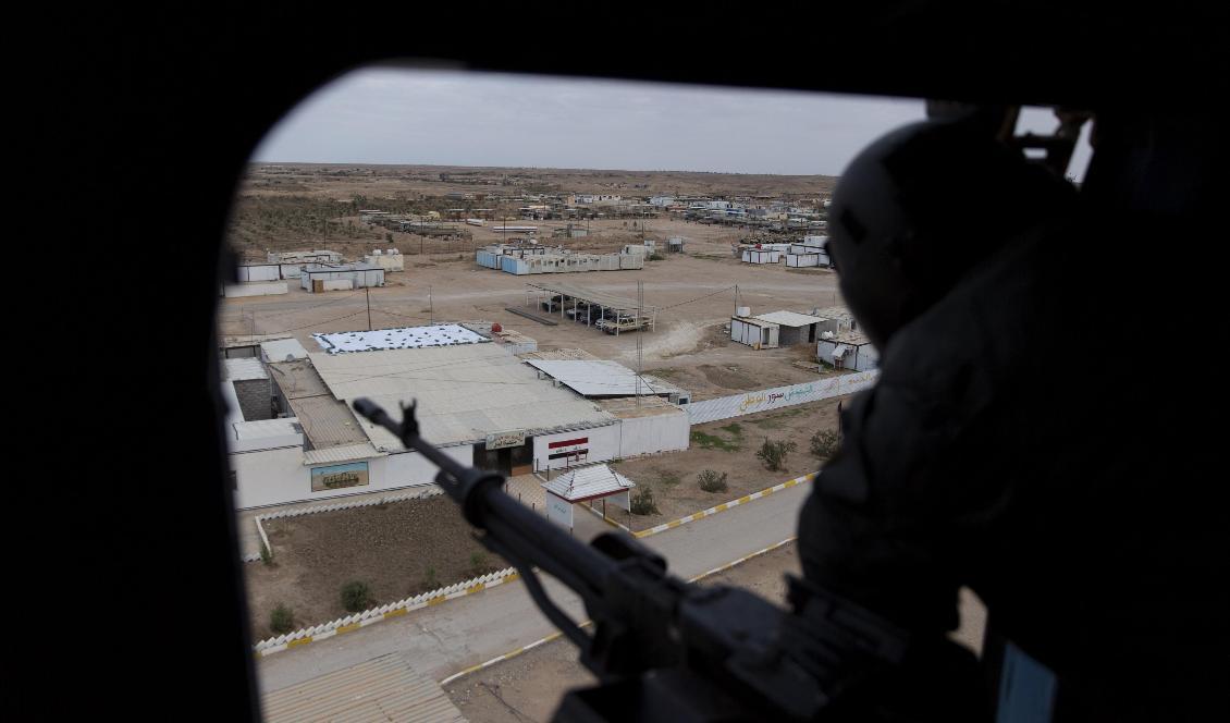 En irakisk soldat blickar ut över al-Qaim från en helikopter. Soldater från den USA-ledda alliansen mot IS har lämnat militärbasen i gränsstaden. Foto: Nasser Nasser/AP/TT-arkivbild