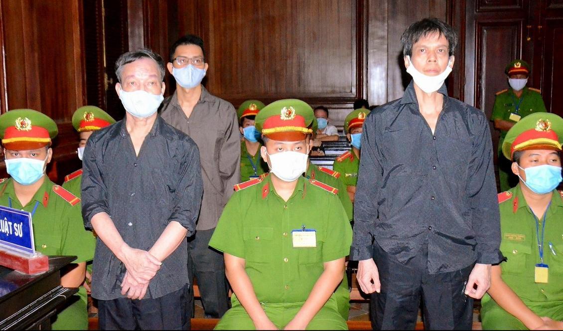 De tre frilansjournalisterna Pham Chi Dung (h), Nguyen Tuong Thuy (v) and Le Huu Minh Tuan (tredje v) under en rättegång i staden Ho Chi Minh i Vietnam. Foto: STR/Vietnam News Agency/AFP via Getty Images