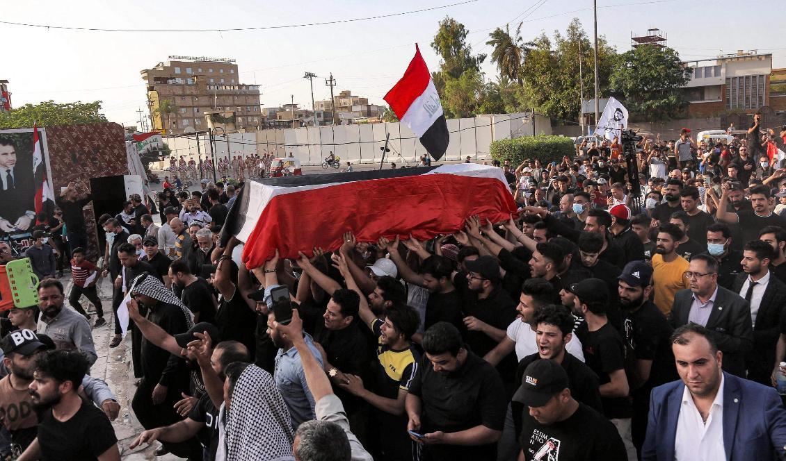 Den ihjälskjutne aktivisten Ihab al-Waznis kropp förs fram av en folkmassa som ropar slagord mot regimen, i Karbala i Irak på söndagen. Foto: Mohammed Sawaf/AFP/TT