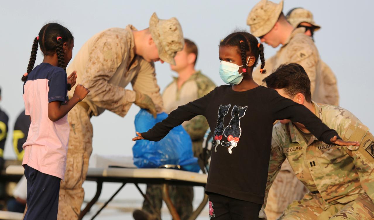 Amerikanska medborgare kroppsvisiteras innan de går ombord ett fartyg i Port Sudan den 30 april. Foto: Smowal Abdalla/AP/TT