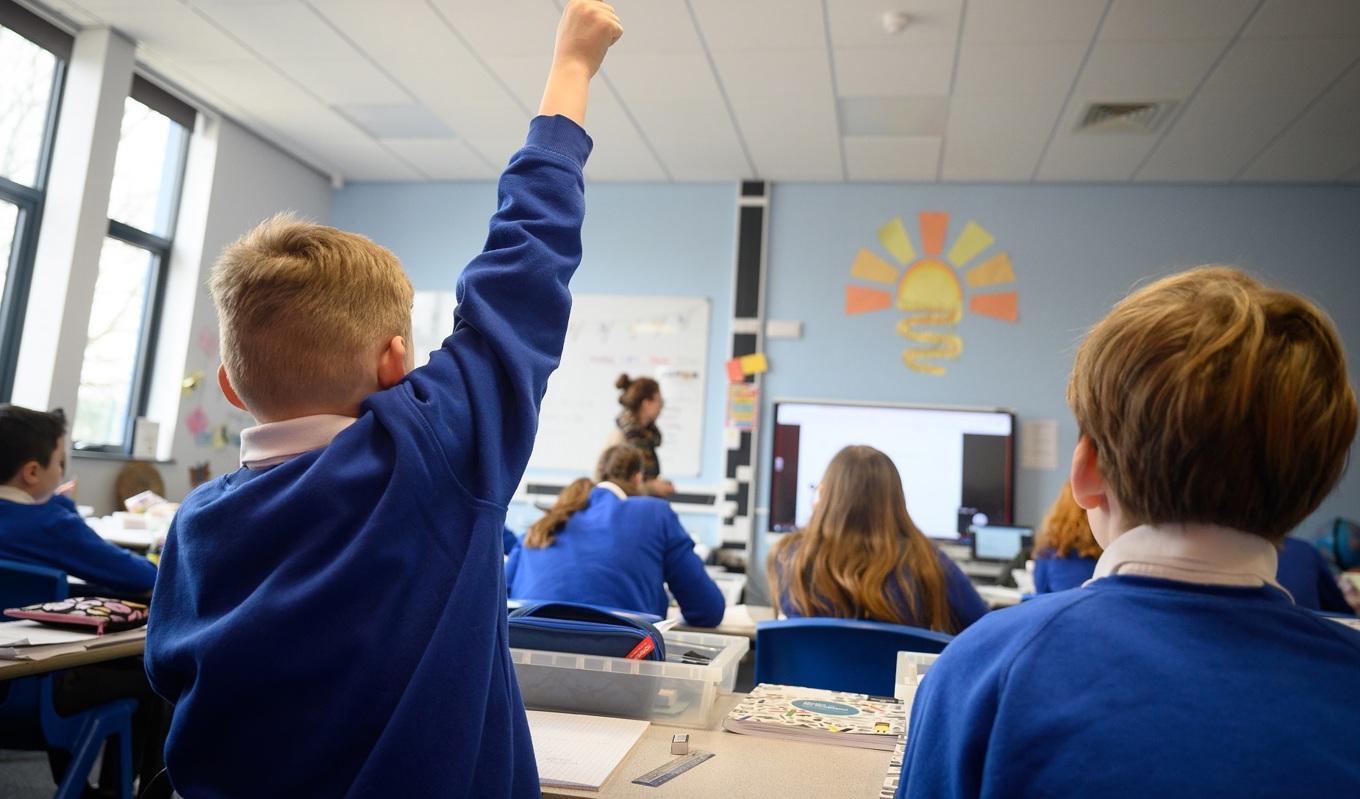 En elev räcker upp handen på en skola i närheten av Bedford i Storbritannien den 8 mars 2021. Foto: Leon Neal/Getty Images