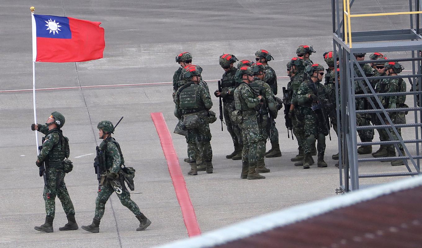 En taiwanesisk soldat håller Taiwans flagga under en stor militärövning i slutet av juli. Den taiwanesiska militären har skakats av flera spionaffärer. Foto: ChiangYing-ying/AP/TT