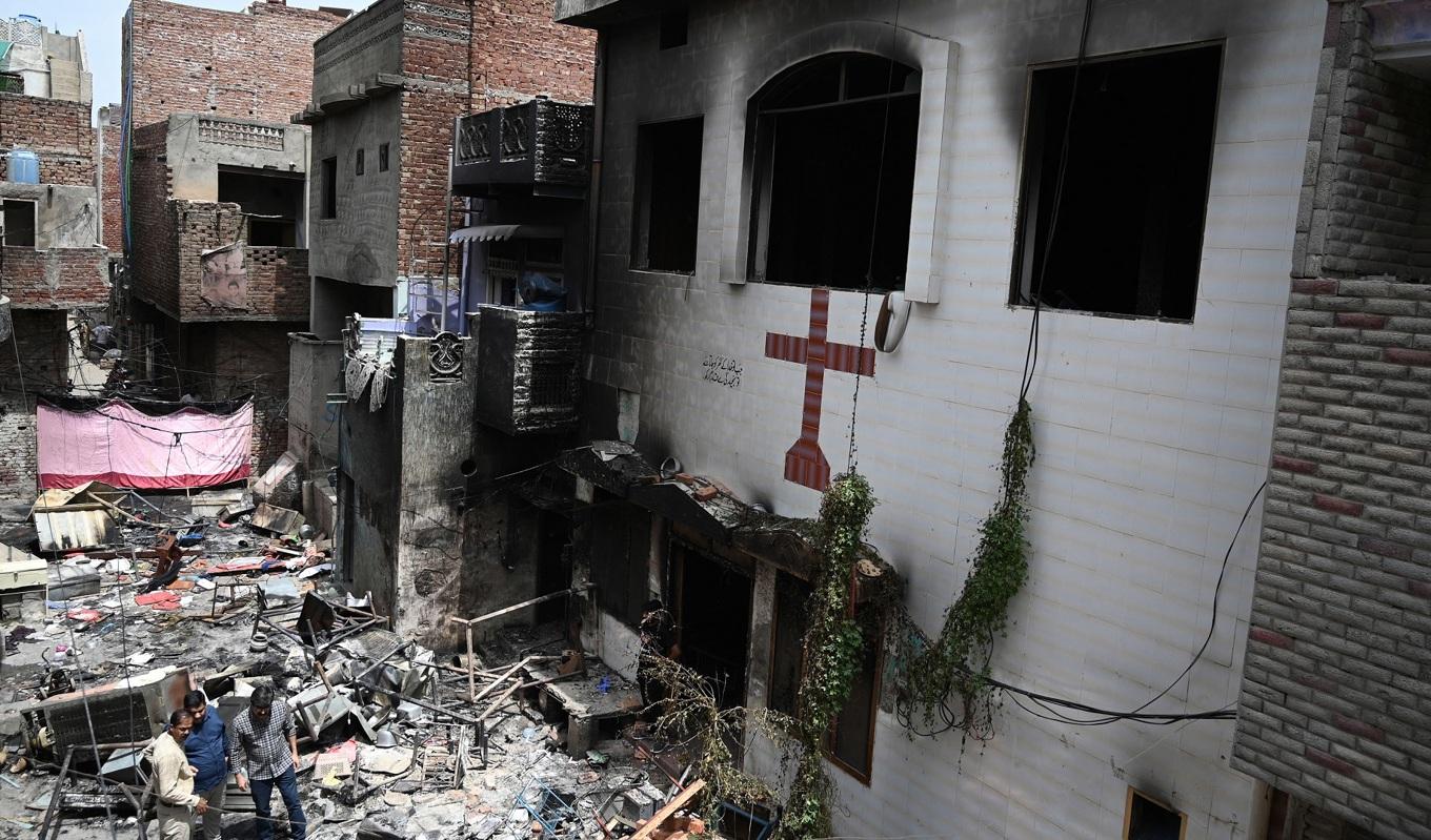 Män står utanför en kyrka i Jaranwala i Faisalabad i Pakistan den 17 augusti efter att muslimer attackerat en rad kyrkor. Foto: Aamir Qureshi/AFP via Getty Images