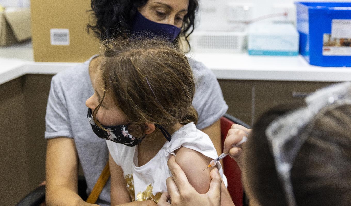 En sköterska ger en flicka covidvaccin i Sydney i Australien. Australien fördjupar sitt samarbete med företaget Moderna kring mRNA-vaccin. Foto: Jenny Evans/Getty Images