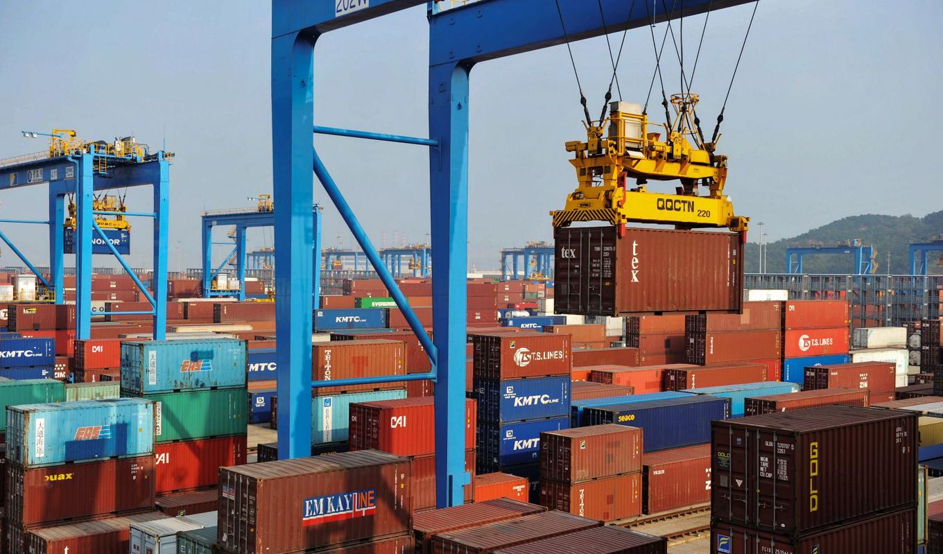 En kran lastar containrar i hamnen i kinesiska Qingdao. Kinas export till de flesta länder minskar. Framför allt Ryssland bryter det mönstret. Foto: STR/AFP via Getty Images