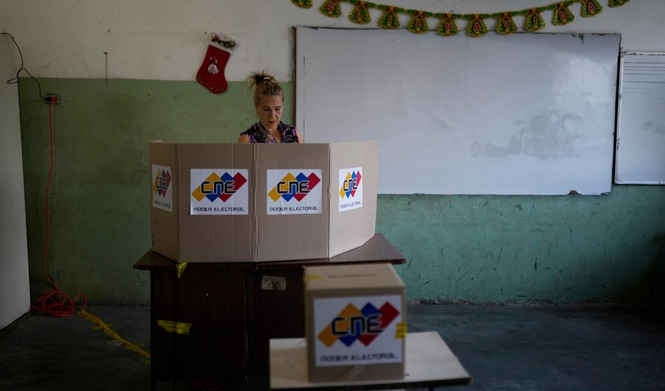 En kvinna i Venzuelas huvdstad Caracas lägger sin röst i samband med folkomröstningen om regionen Essequibo, som tillhör Guyana. Foto: Ariana Cubillos/AP/TT