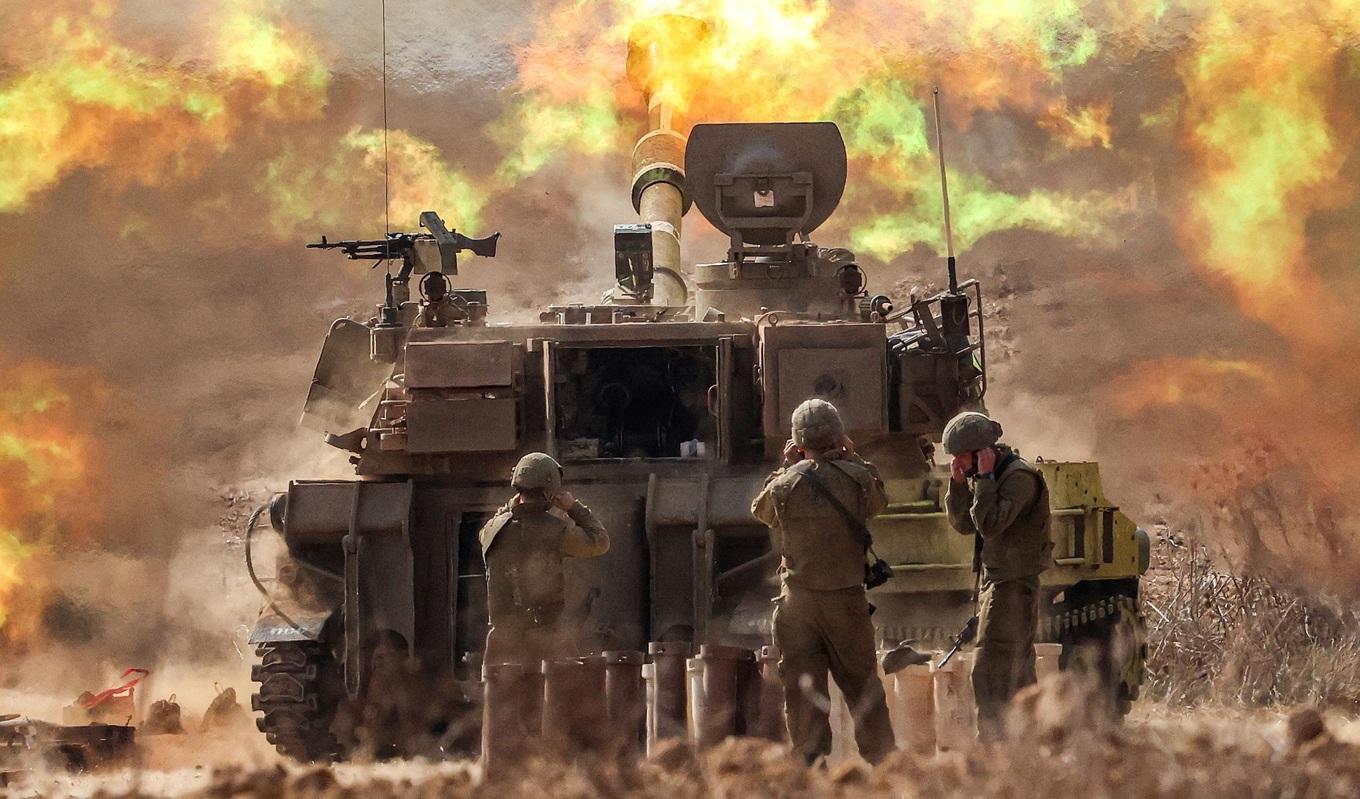 En israelisk M109 155 mm haubits avfyras nära gränsen till Gaza den 11 oktober 2023. Experter menar nu att konflikten riskerar att utökas. Foto: Jack Guez/AFP via Getty Images