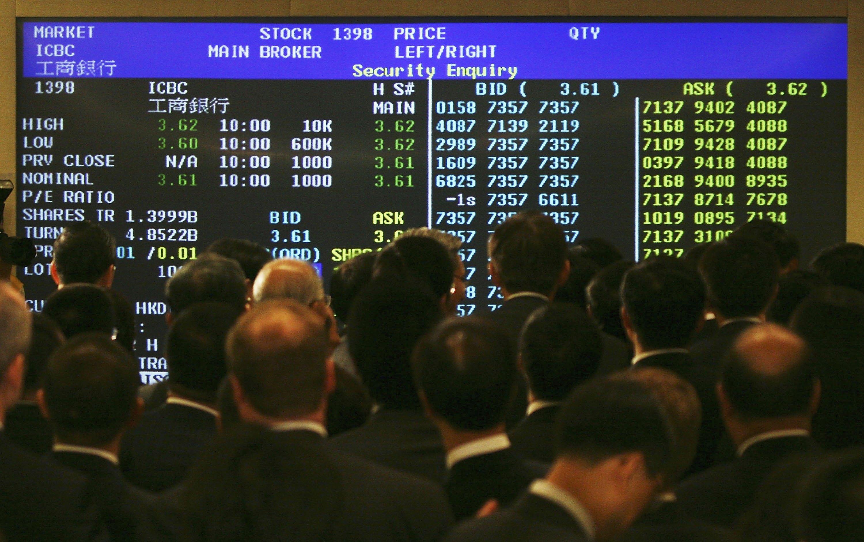 Människor tittar på en elektronisk tavla i Hongkong. Foto: MN Chan/Getty Images