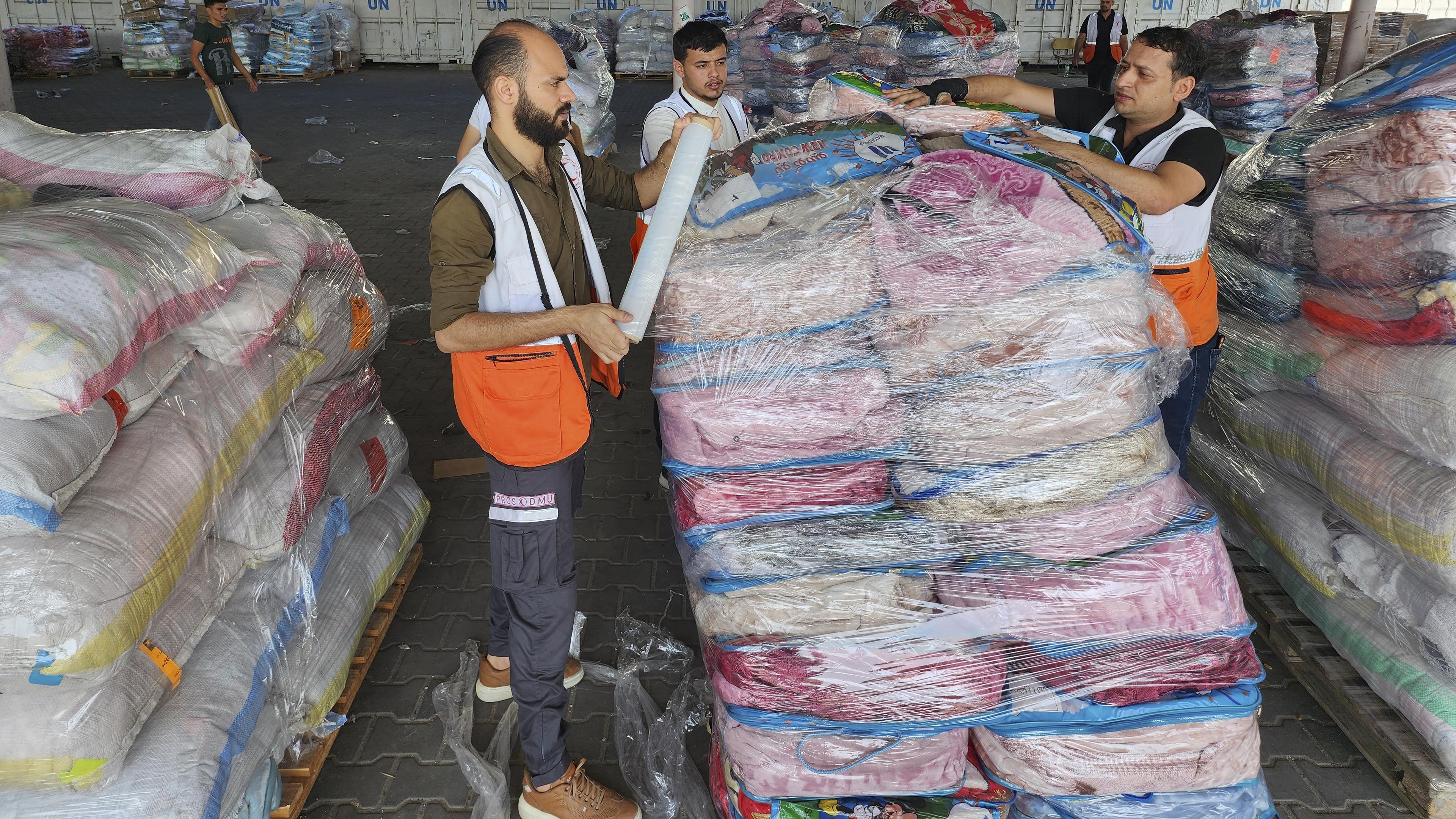 Medarbetare för FN och Röda halvmånen i ett nödhjälpslager som tillhör FN-organet Unrwa på Gazaremsan. Arkivbild. Foto: Hassan Eslaiah/AP/TT