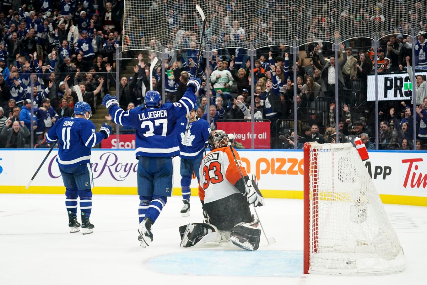 Torontos back Timothy Liljegren (37) på väg fram för att gratulera William Nylander efter att svensken i förlängningen avgjorde matchen mot Philadelphia natten mot fredagen. Foto: Arlyn McAdorey/AP/TT