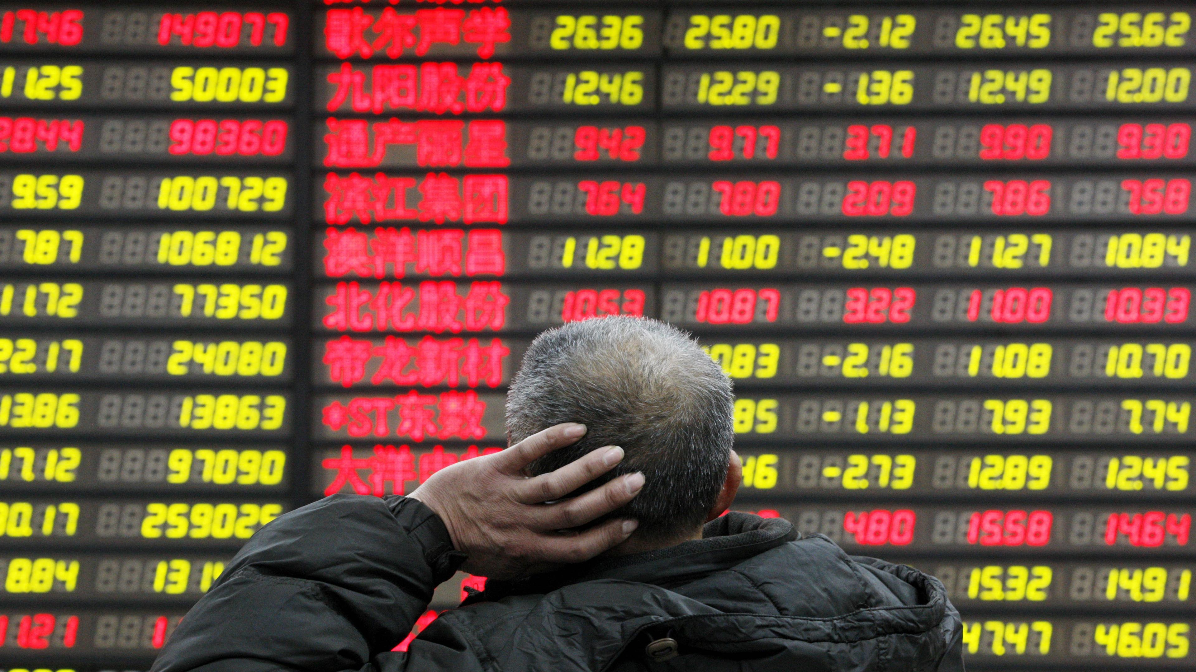 En man betraktar aktiekurserna på Shanghaibörsen. Kinas regim har försökt hindra aktiekursen från att sjunka bland annat genom statliga investeringar. Foto: VCG/VCG via Getty Images