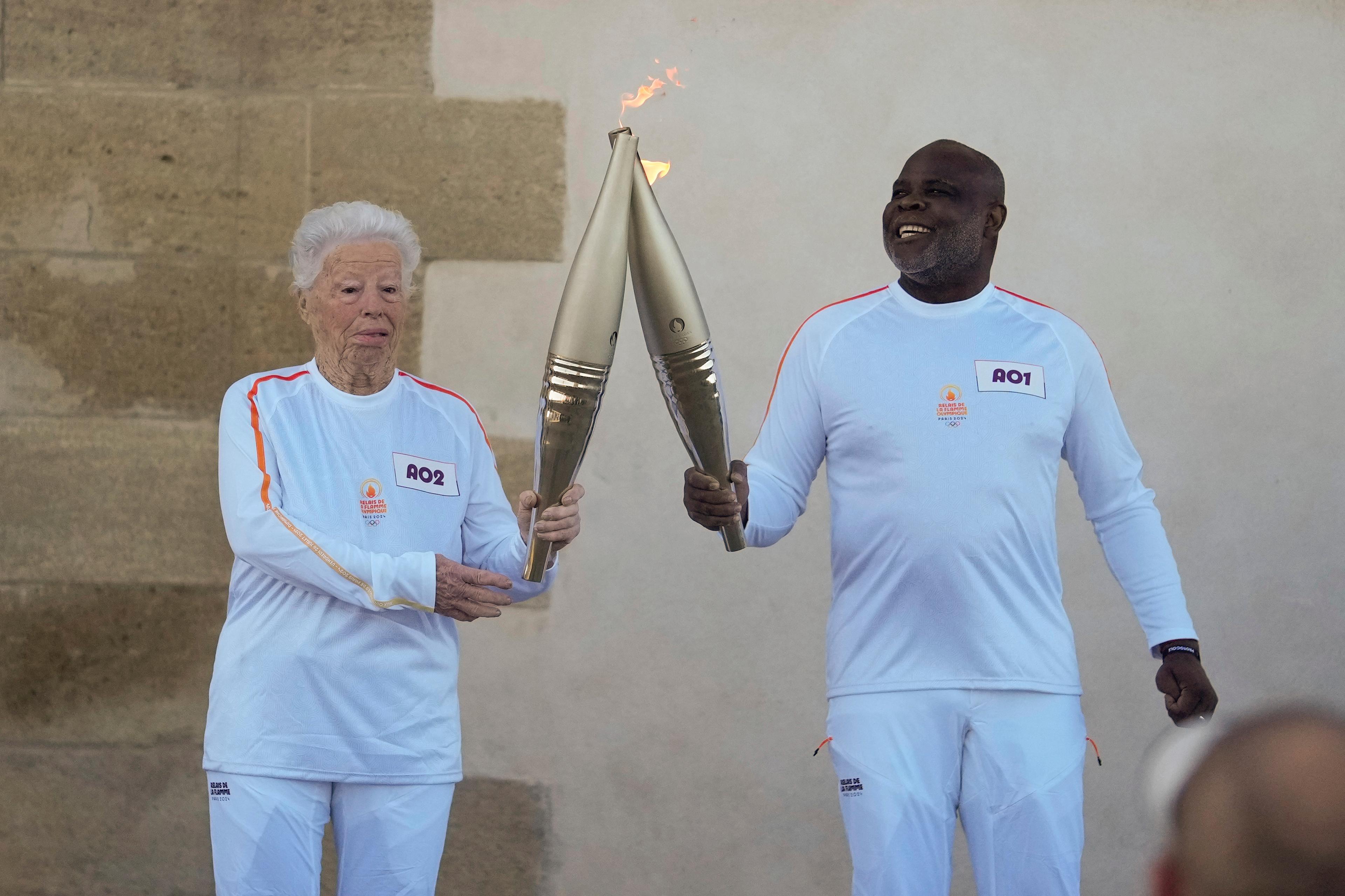 Colette Cataldo och Basile Boli med den olympiska facklan i Marseille. Foto: Thibault Camus/AP/TT