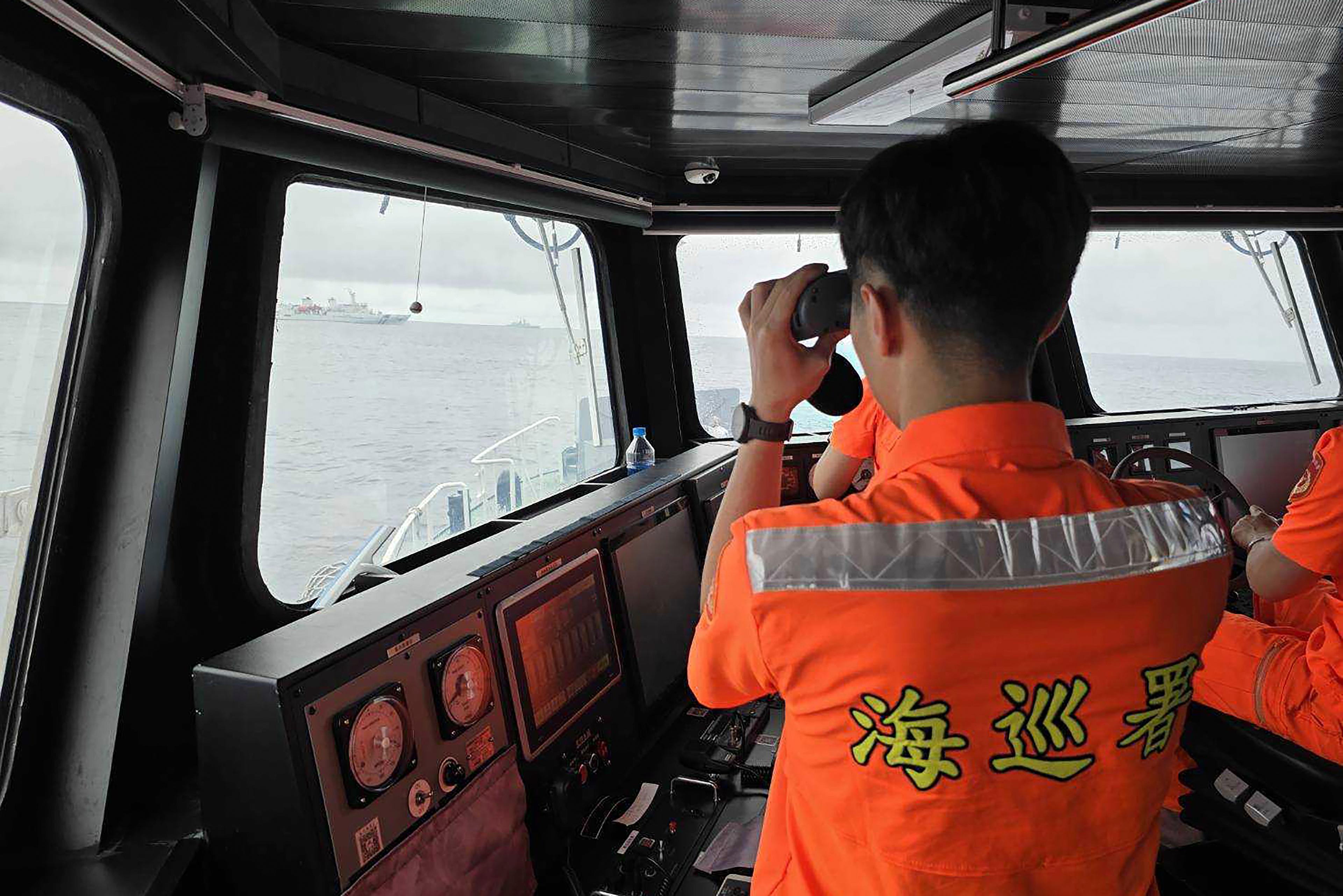 En anställd vid kustbevakningen i Taiwan övervakar ett kinesiskt fartyg i närheten av norra Taiwan på torsdagen. Foto: AP/TT
