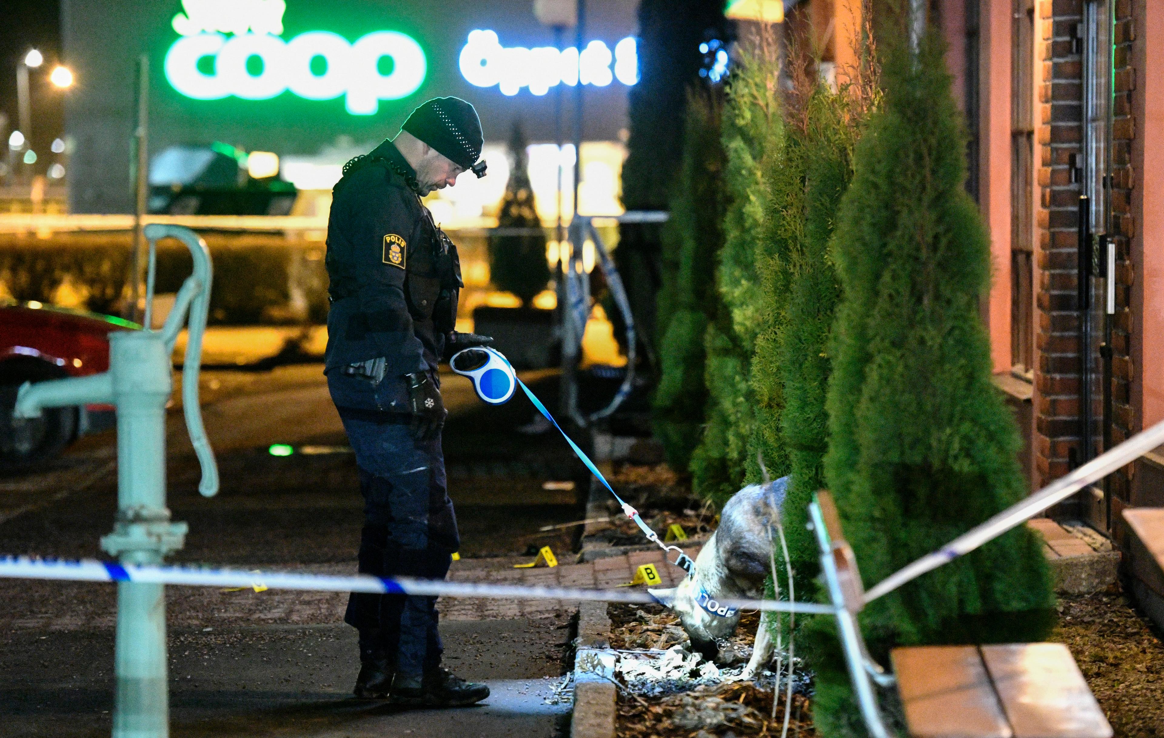 Polis med hund undersöker den plats utanför en restaurang i handelsområdet Boländerna i Uppsala där en man i 40-årsåldern sköts till döds i april 2017. Arkivbild. Foto: Johan Nilsson/TT