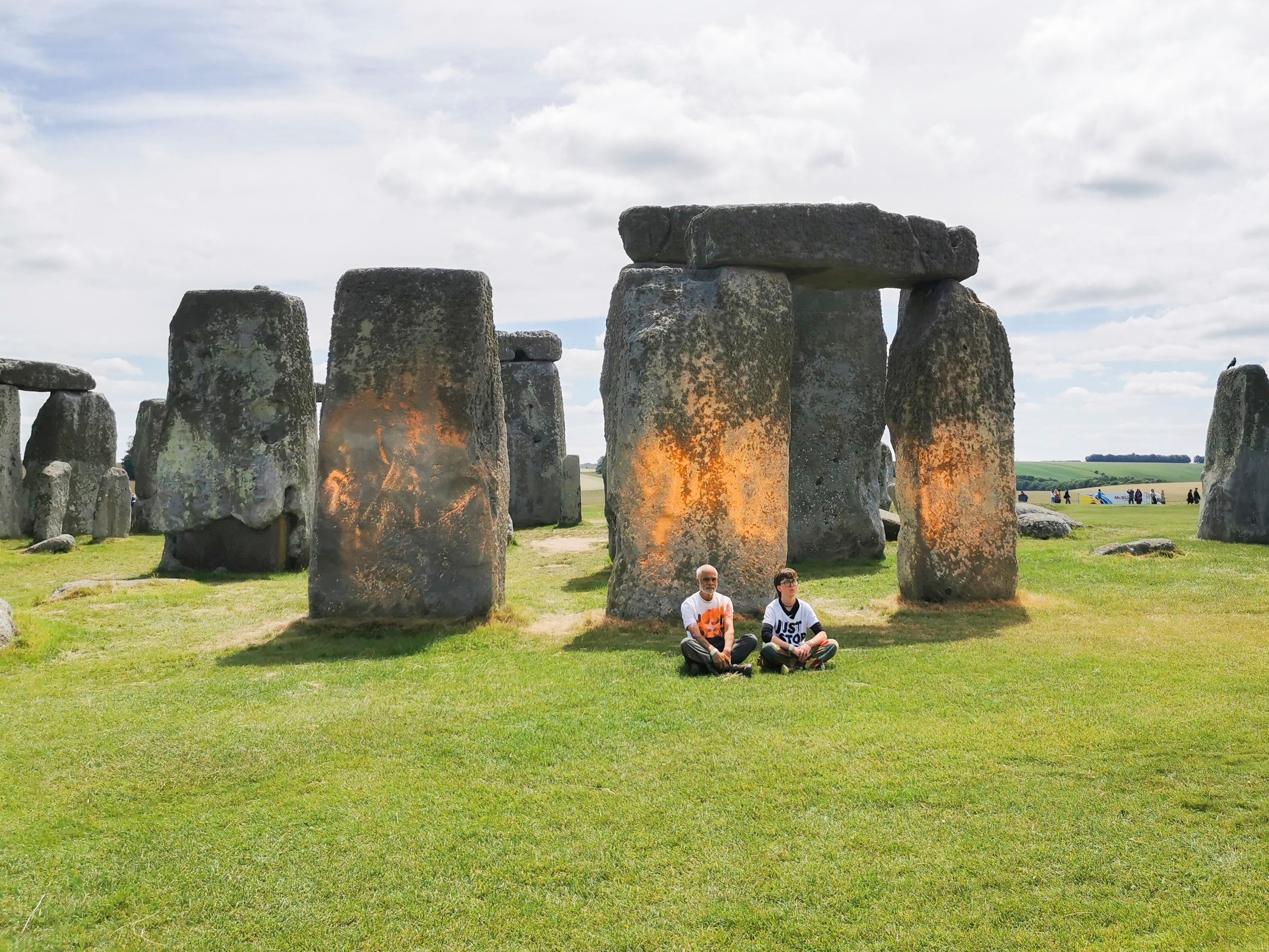 Aktivisterna satte sig ned efter att ha sprejat den förhistoriska stensättningen Stonehenge. Foto: Just Stop Oil via AP/TT