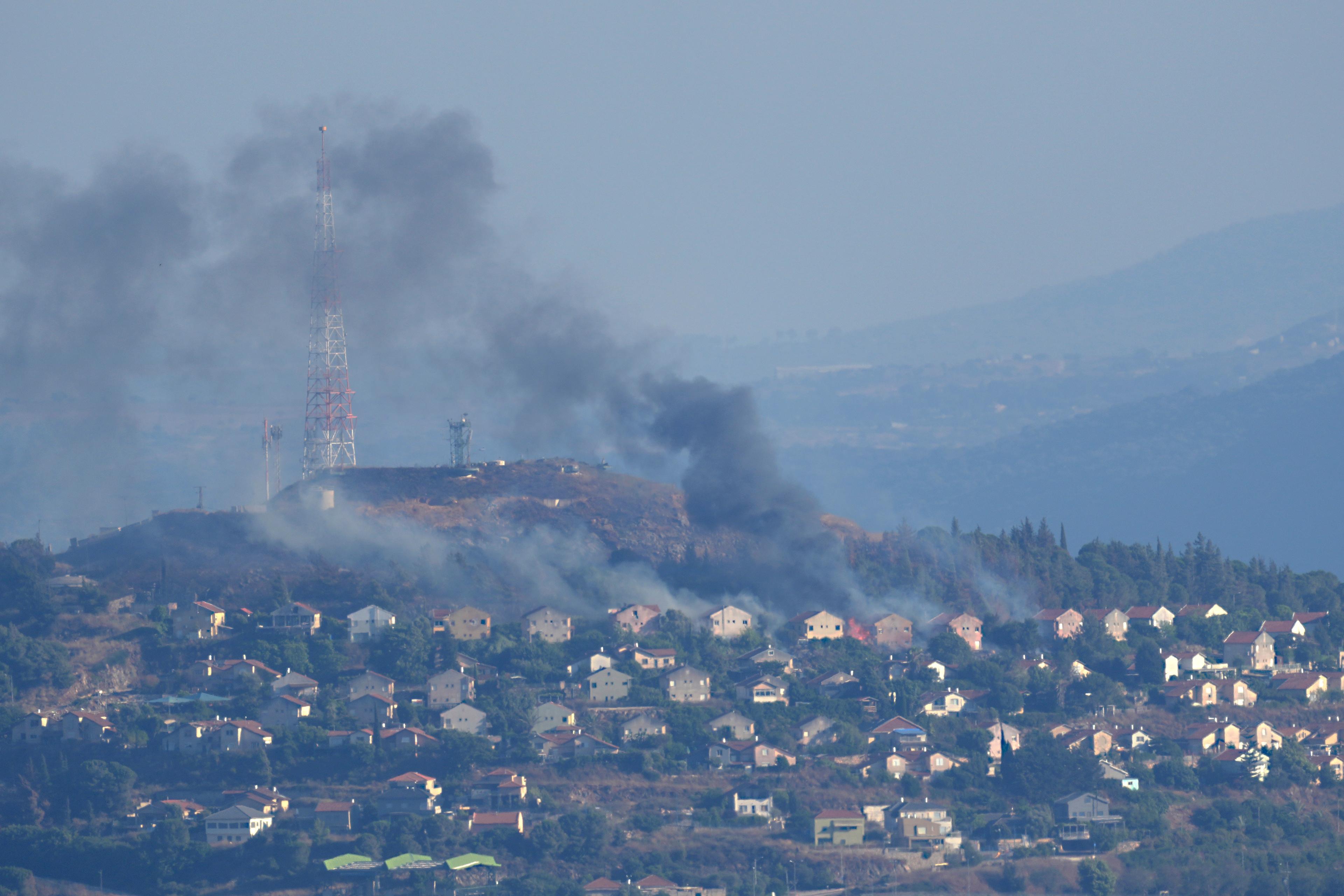 Svart rök stiger mellan husen i en israelisk by på gränsen till Libanon, efter att Hizbollah avfyrat bomber. Läget mellan de båda länderna är spänt. Bilden togs under lördagen. Foto: Hussein Malla/AP/TT