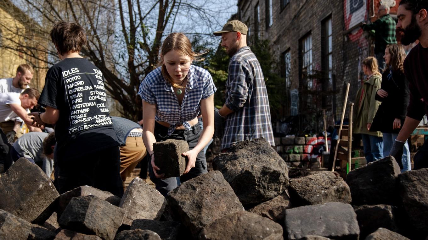 Invånare i stadsdelen Christiania gräver upp kullerstenar på Pusher Street. Foto: Ida Marie Odgaard/Ritzau Scanpix/AFP via Getty Images