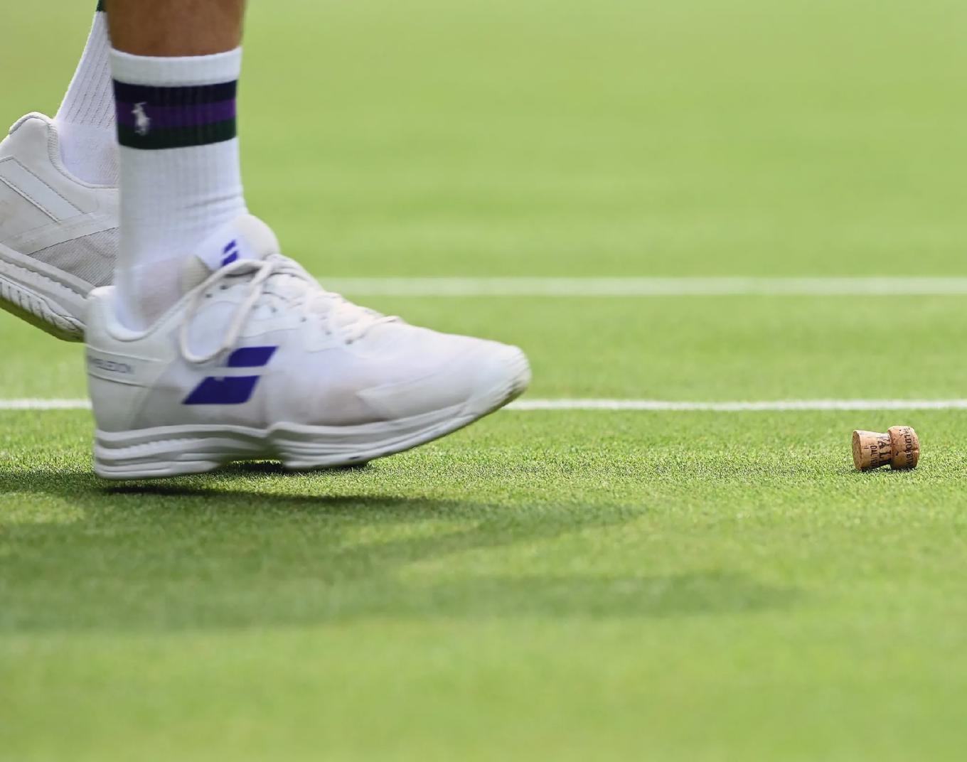 En champagnekork syns 2021 på centercourten under matchen mellan amerikanskan Coco Gauff och ryskan Elena Vesnina. Förutom champagne och Pimm’s No. 1 är Wimbledon även förknippat med jordgubbar och grädde. En uppgift gör gällande att man under de två veckor som turneringen pågår, serverar 191 930 portioner. Foto: Glyn Kirk/AFP via Getty Images