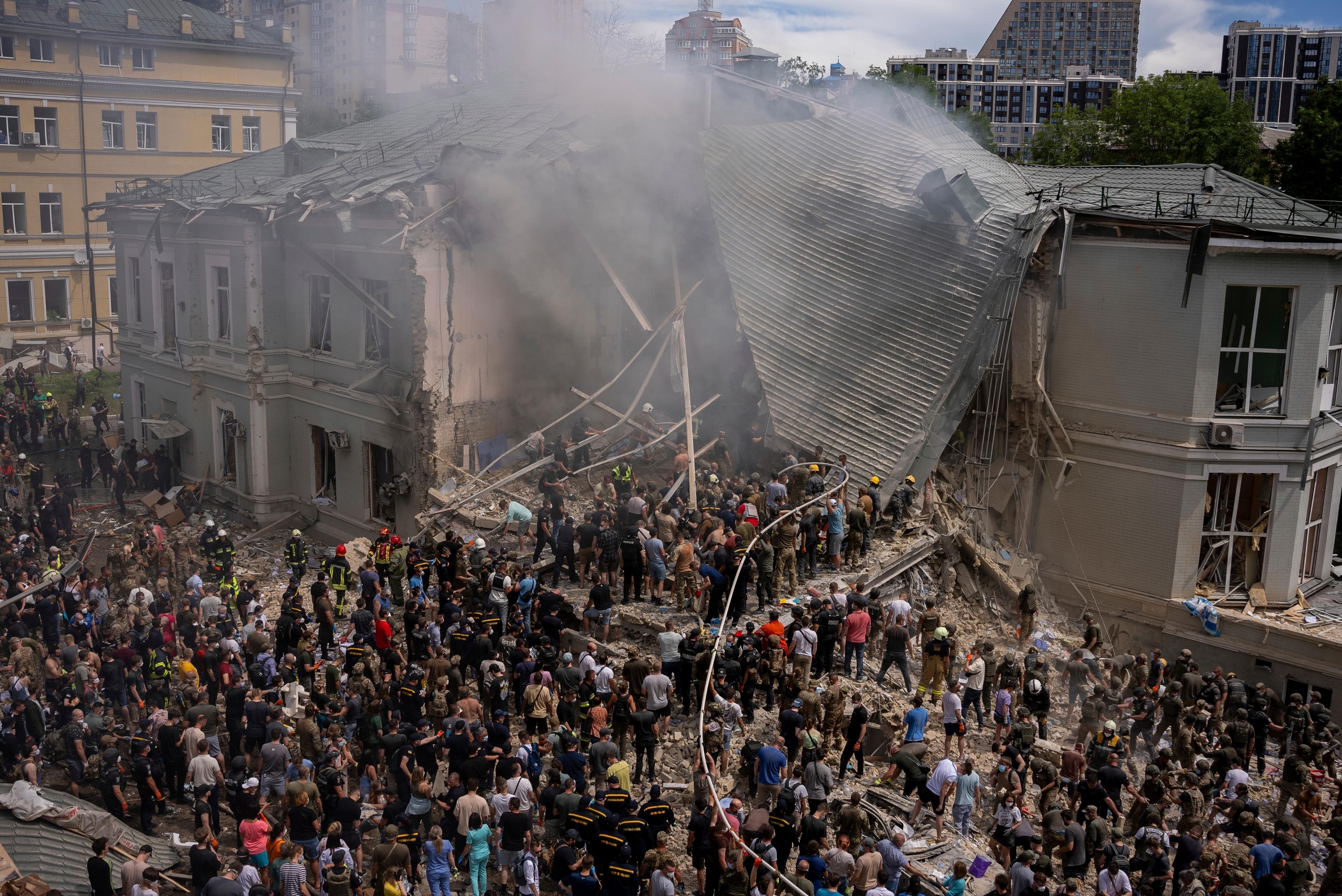 Räddningsarbetare, volontärer och vårdpersonal söker igenom rasmassorna vid barnsjukhuset Ochmatdyt i Kiev efter måndagens ryska robotattack. Foto: Alex Babenko/AP/TT