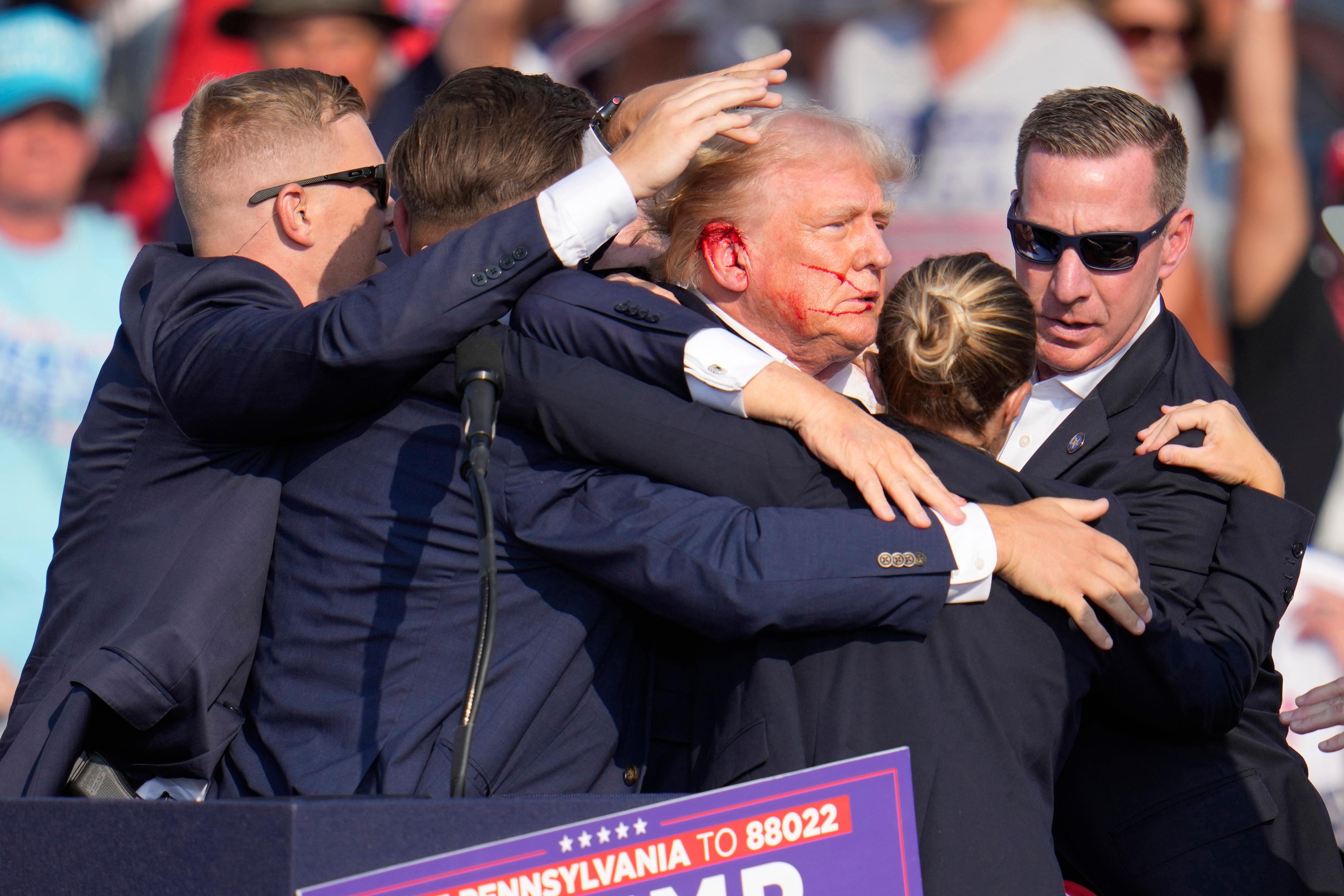 Donald Trump eskorteras bort av vakter efter mordförsöket. Foto: Gene J. Puskar/AP/TT