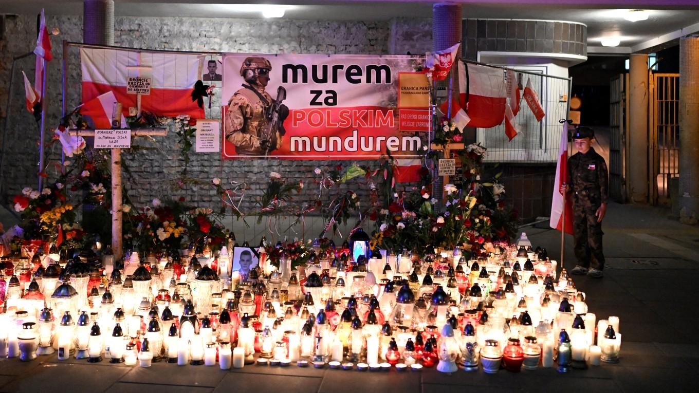 En pojke besöker minnesmärket till Mateusz Sitek, en polsk soldat som dödades av en migrant vid gränsen mellan Polen och Belarus, framför militärsjukhuset i Warszawa den 7 juni 2024. Foto: Sergei Gapon/AFP via Getty Images