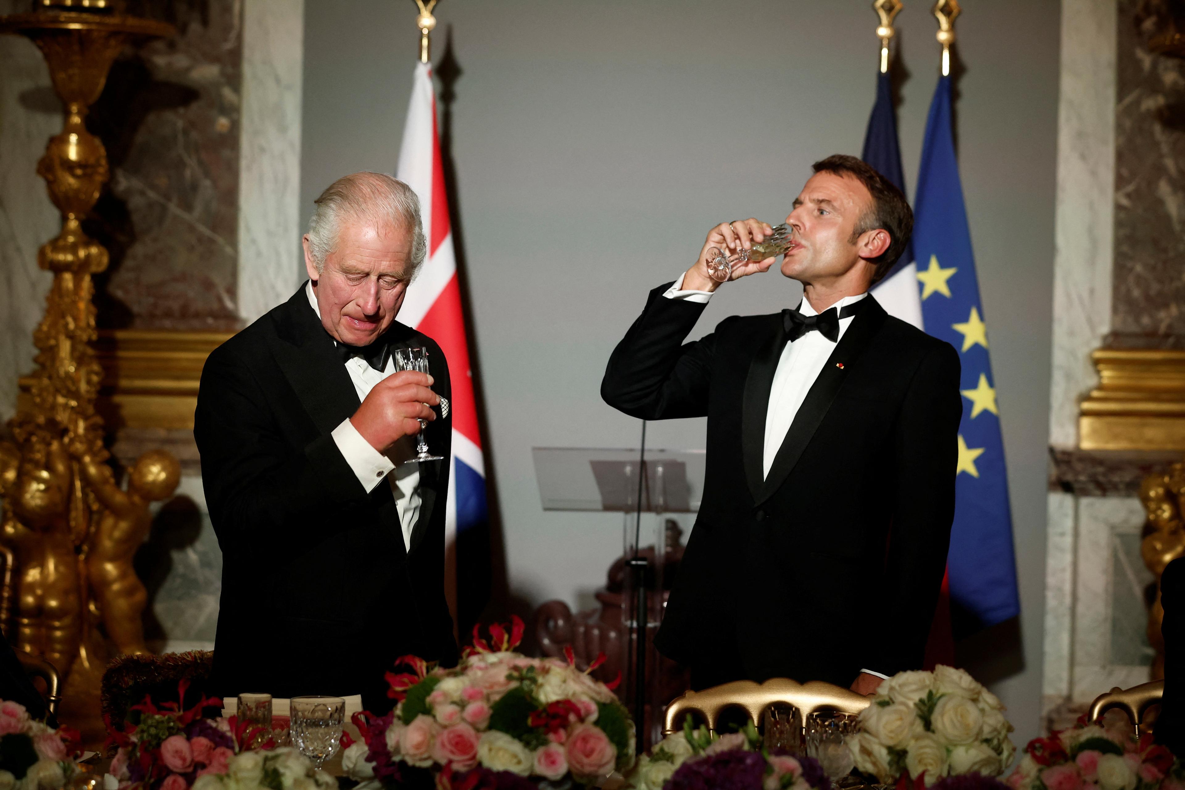 President Macron skålar med kung Charles i spegelsalen i slottet Versailles. Foto: Benoit Tessier/AP/TT