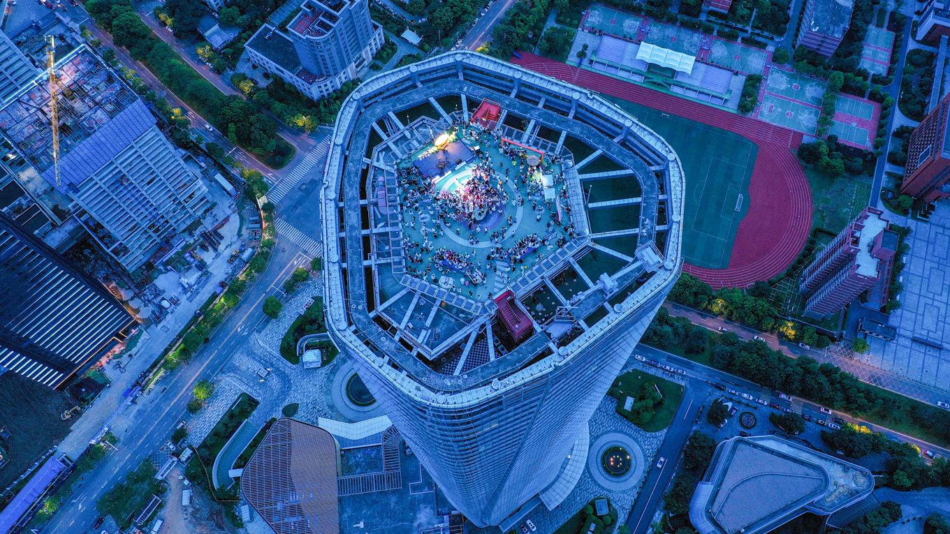 Ett band spelar högst upp på en skyskrapa i Nanchang, huvudstaden i Jiangxi. Det är en av flera städer där privatinvesterare lurats på sina pengar. Foto: STR/AFP via Getty Images