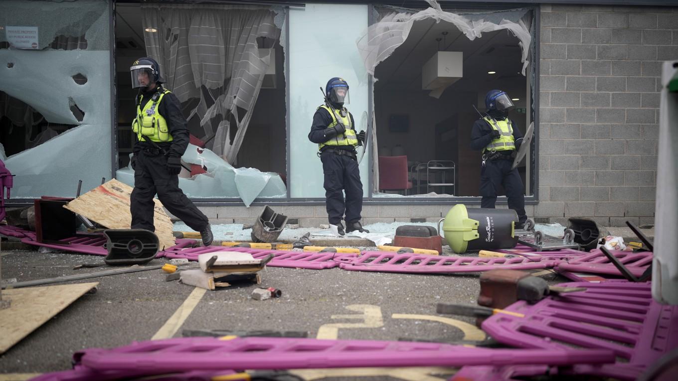 Kravallpolis framför krossade fönster i Rotherham i Storbritannien. Foto: Christopher Furlong/Getty Images