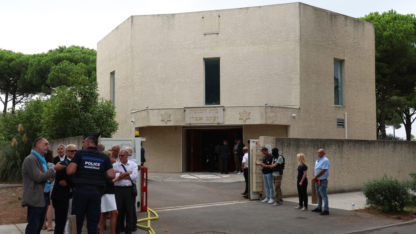 Polis talar utanför en synagoga i staden La Grande-Motte i södra Frankrike den 24 augusti. Två bilar sattes i brand utanför synagogan vilket ledde till en explosion samma dag. En polisman skadades i samband med händelsen. Foto: Pascal Guyot/AFP via Getty Images