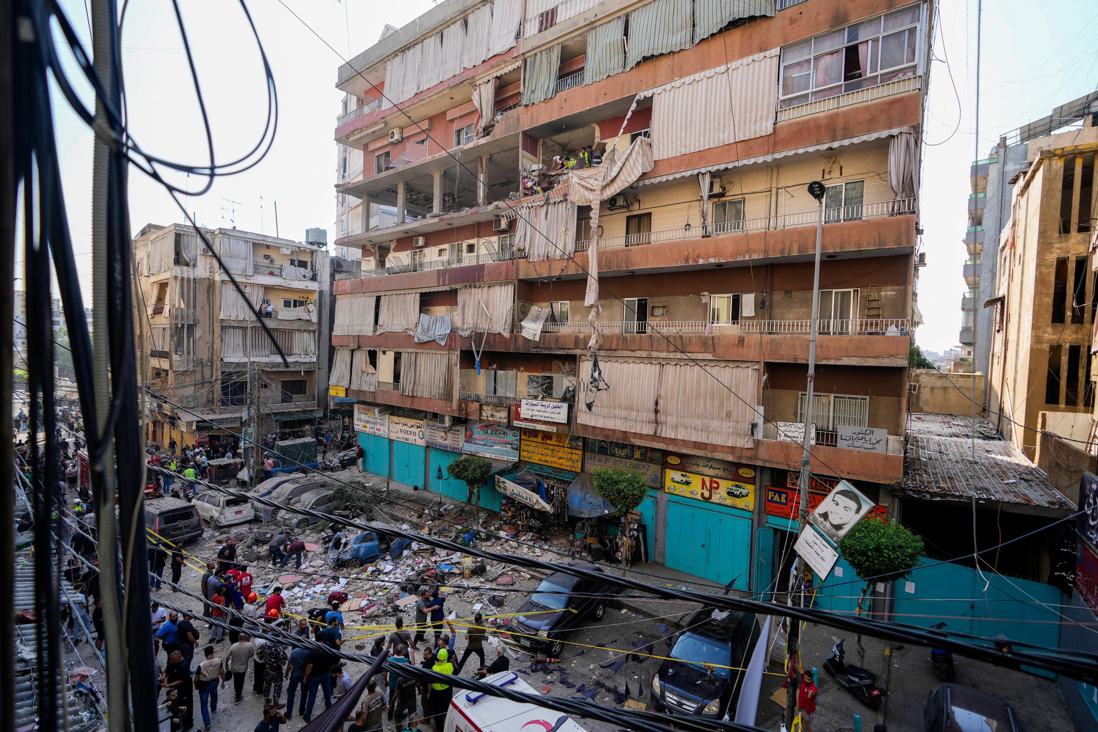 Invånare och räddningsarbetare utanför ett attackerat hus i södra Libanon på tisdagen. Foto: Hassan Ammar/AP/TT