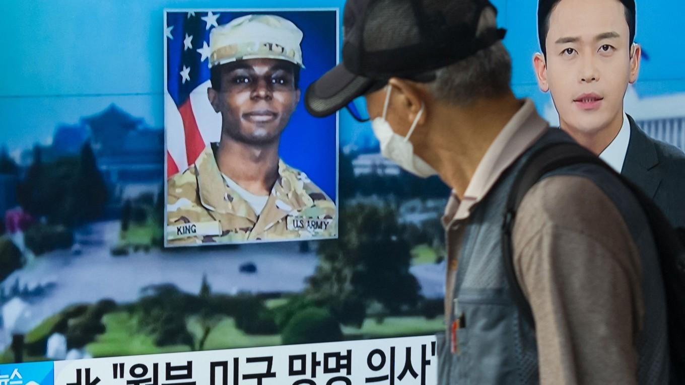 På bilden som är tagen den 16 augusti går en man förbi en tv som visar en nyhetssändning med ett foto av den amerikanske soldaten Travis King som tog sig över till Nordkorea från Sydkorea. Foto: Anthony Wallace/AFP via Getty Images