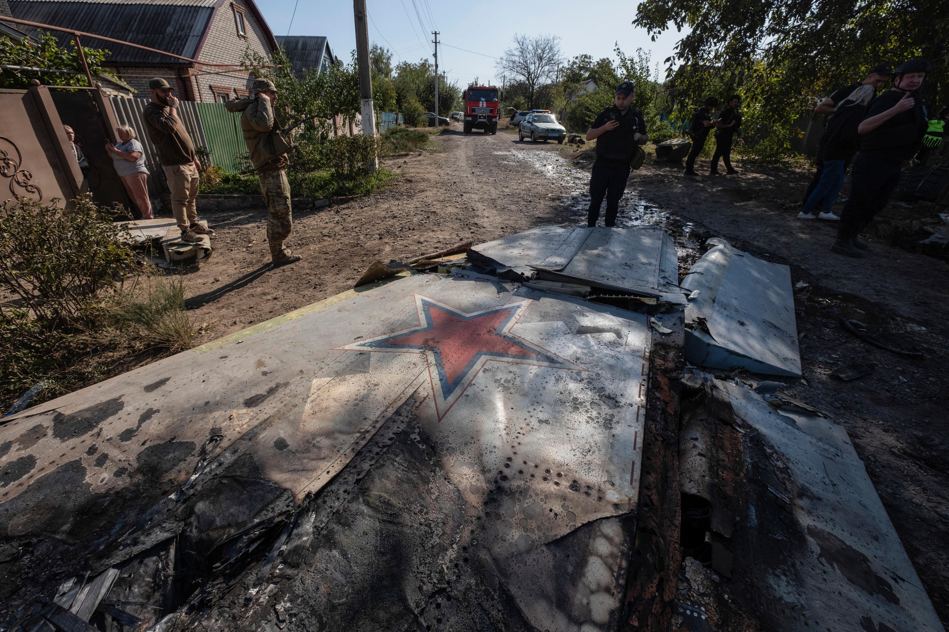 Ukrainska soldater vid resterna av en rysk militär luftfarkost som sköts ner i utkanten av Kostiantynivka under lördagen. Foto: Iryna Rybakova/AP/TT