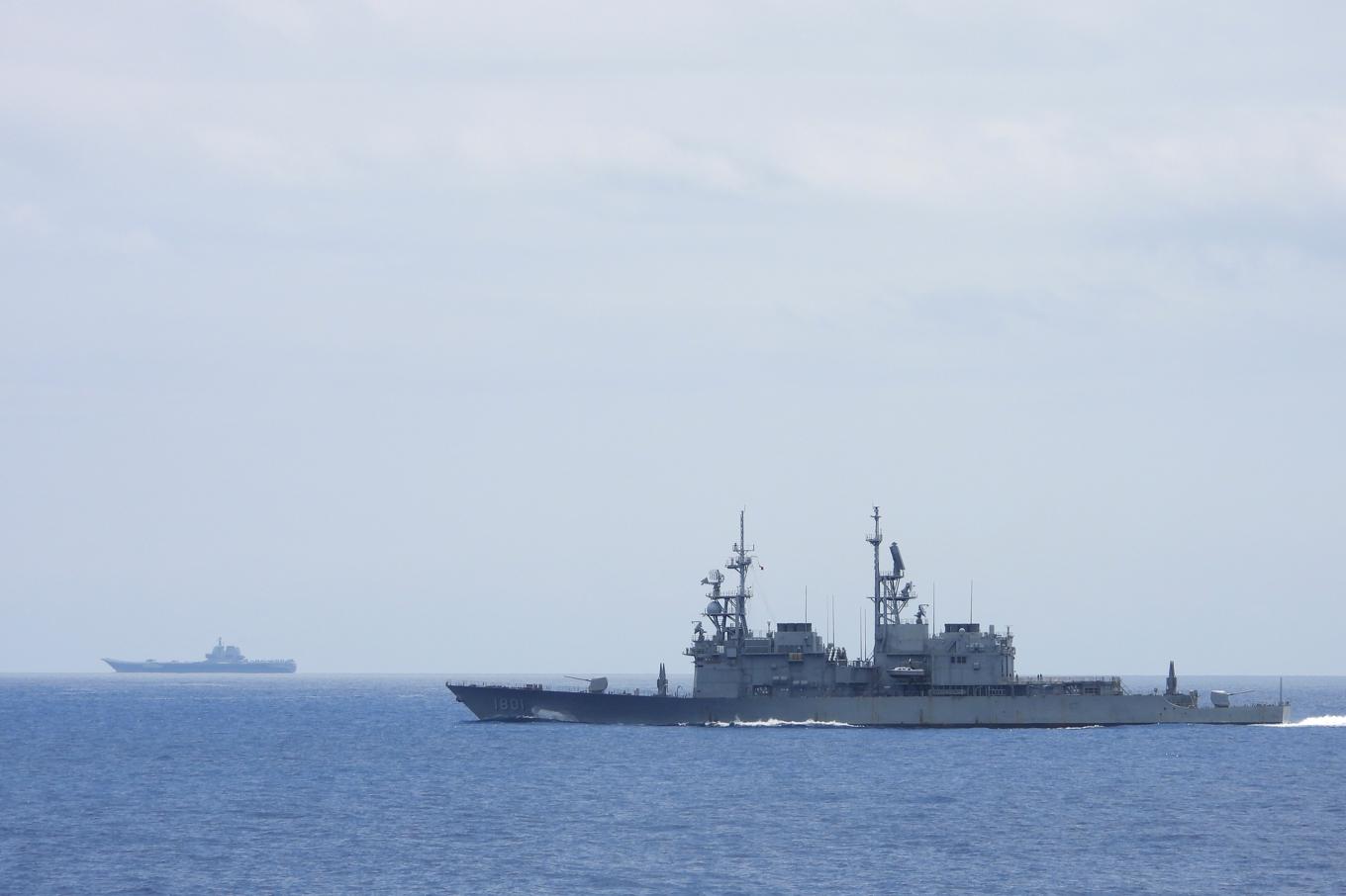 Taiwanesiska flottans fartyg i förgrunden och ett kinesiskt hangarfartyg i bakgrunden. Arkivbild. Foto: Taiwans försvarsdepartement via AP/TT