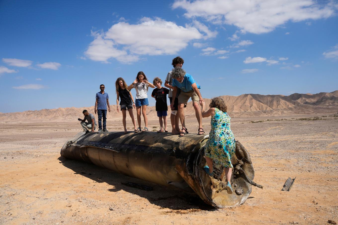 Barn klättrar på delar av en iransk robot som skjutits ned av israeliskt luftvärn. Bild tagen nära Arad i södra Israel den 2 oktober, dagen efter Irans senaste robotanfall mot Israel. Foto: Ohad Zwigenberg/AP/TT