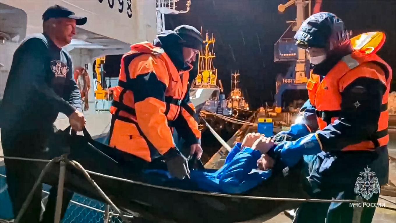 Den räddade mannen tas i land efter att ha fiskats upp av ett fartyg från en gummibåt i Ochotska havet. Han har varit på drift sedan i augusti. Foto: Rysslands beredskapsdepartement via AP/TT