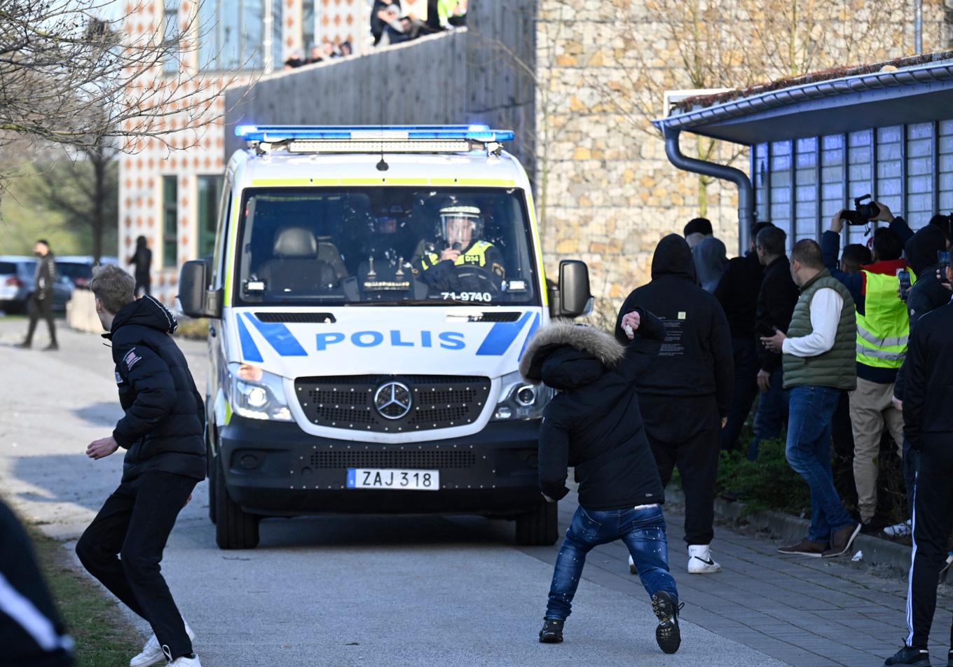 Motdemonstranter kastar sten mot en polisbuss i samband med Rasmus Paludans sammankomst vid Skånegården i Malmö i april 2022. Foto: Johan Nilsson/TT